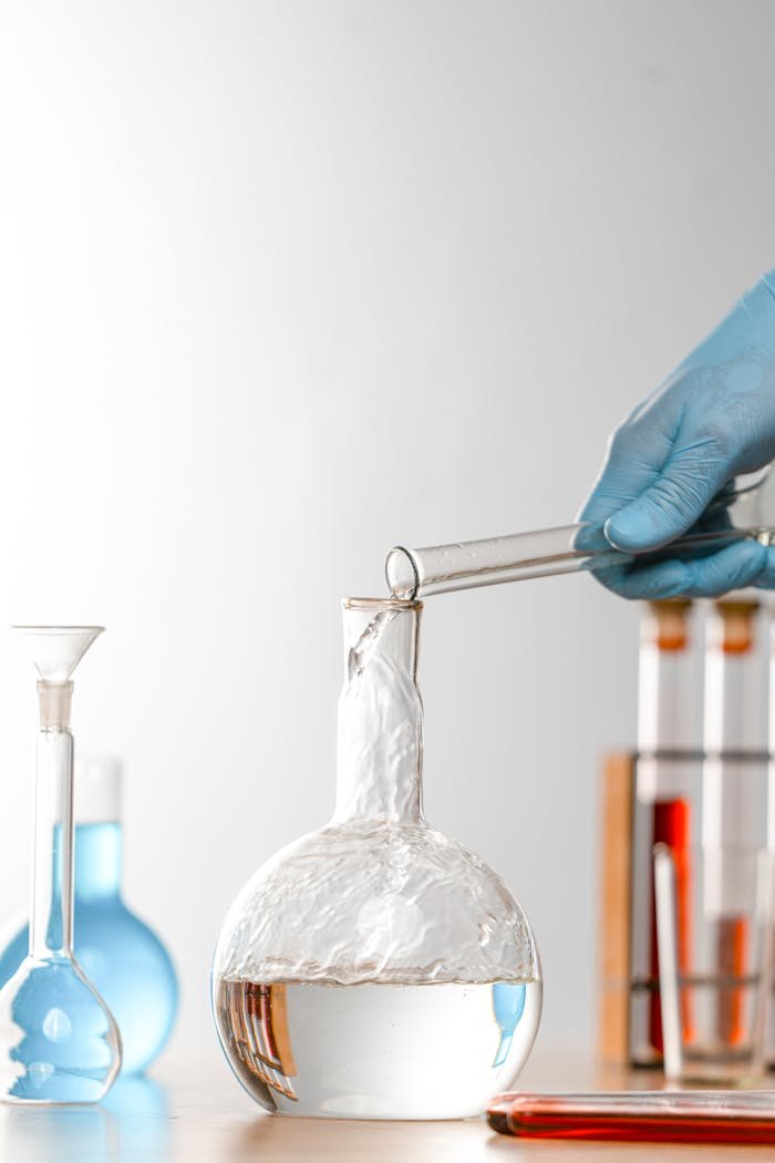 Close-up of a scientist pouring liquid into glassware in a lab setting, focus on research.